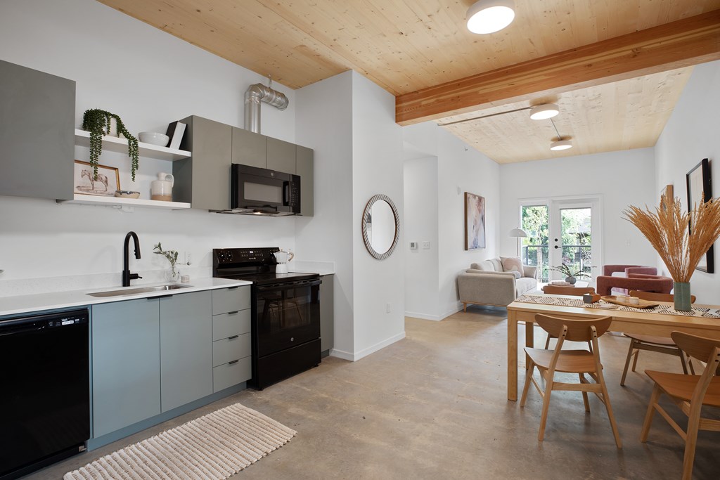 A kitchen with a wooden ceiling and a dining table with chairs.