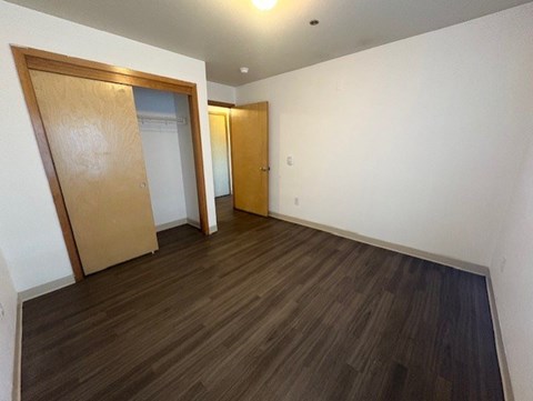 A room with a wooden floor and two doors.