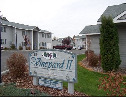 a sign for emerald ii in front of some houses