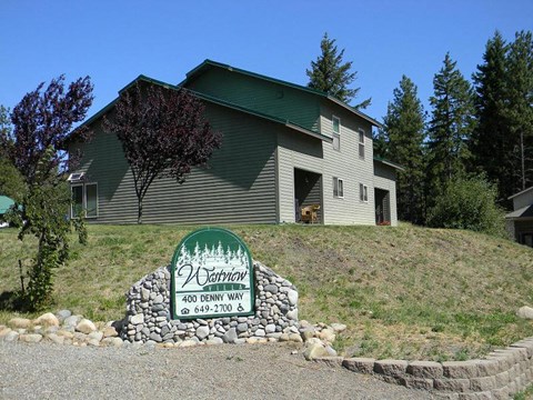 a green and white sign in front of a house
