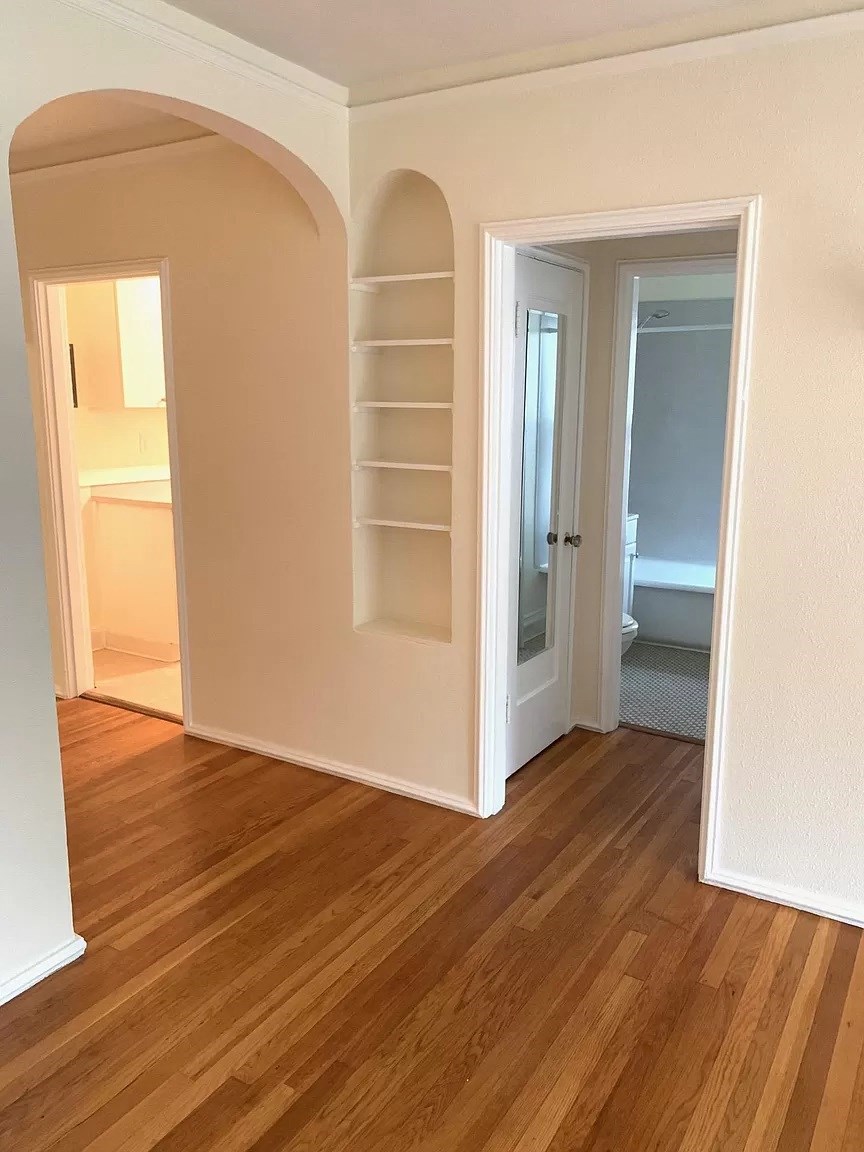 an empty room with a wooden floor and a closet