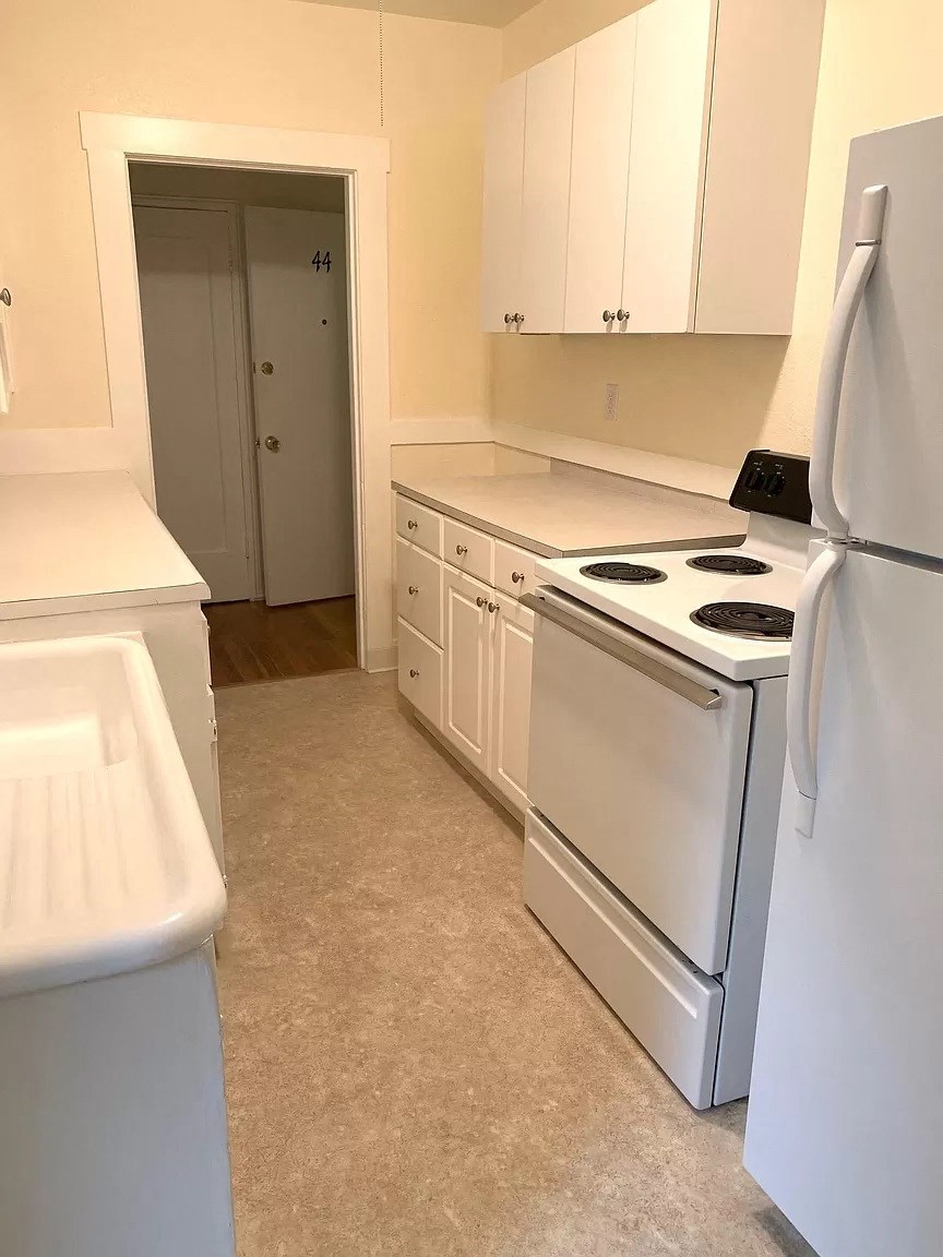a kitchen with white appliances and white cabinets