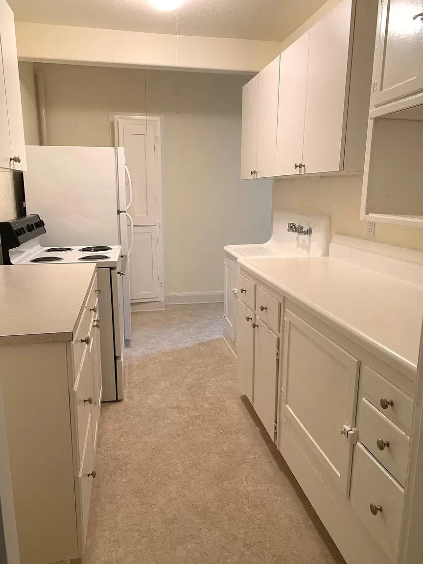 a white kitchen with white cabinets and white appliances