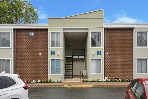Apartment building with a car parked in front.