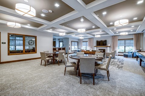 A spacious dining room with a large table and chairs.