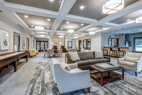 A spacious living room with a variety of seating options and a large rug.