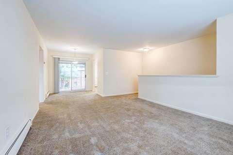 A spacious room with carpeted floor and white walls.