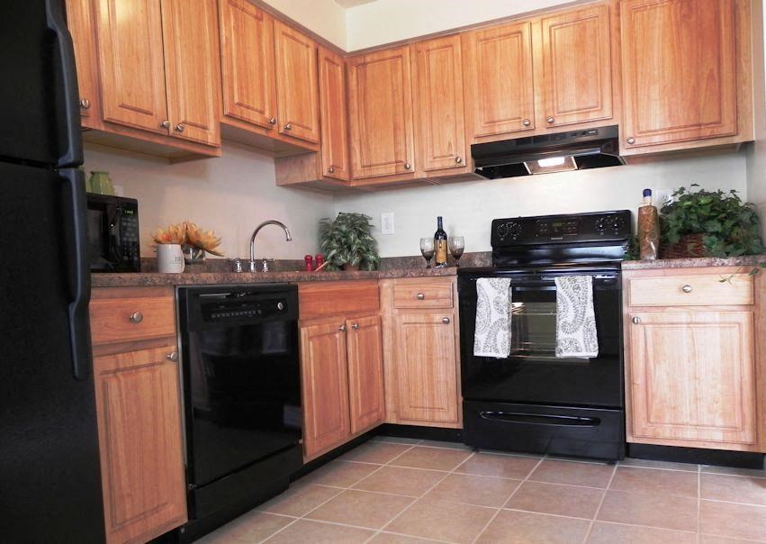 a kitchen with black appliances and wooden cabinets