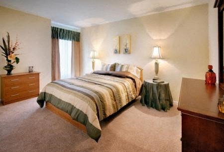 a bedroom with a bed and a table and a window