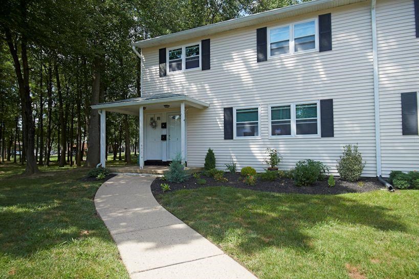 a white house with a sidewalk in front of it