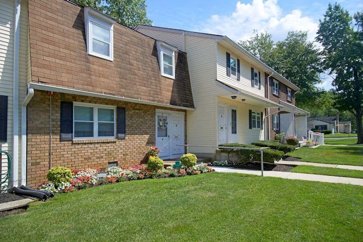 a brick house with a lawn and a sidewalk
