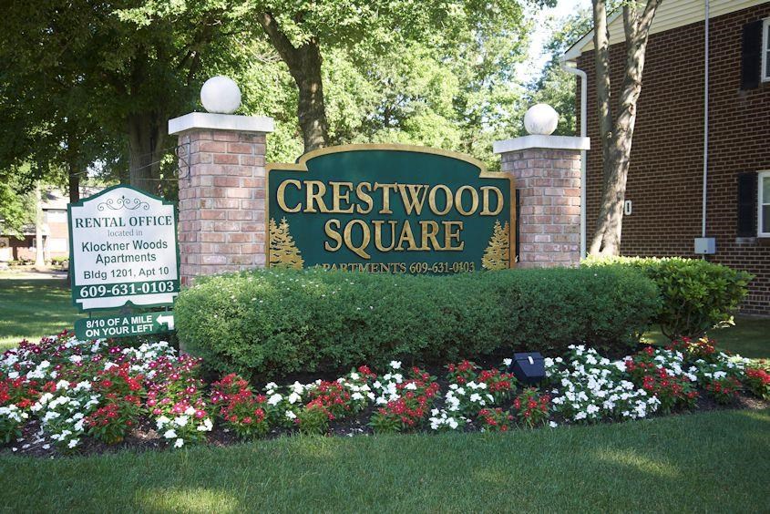 a sign for the cresswood square in front of a garden