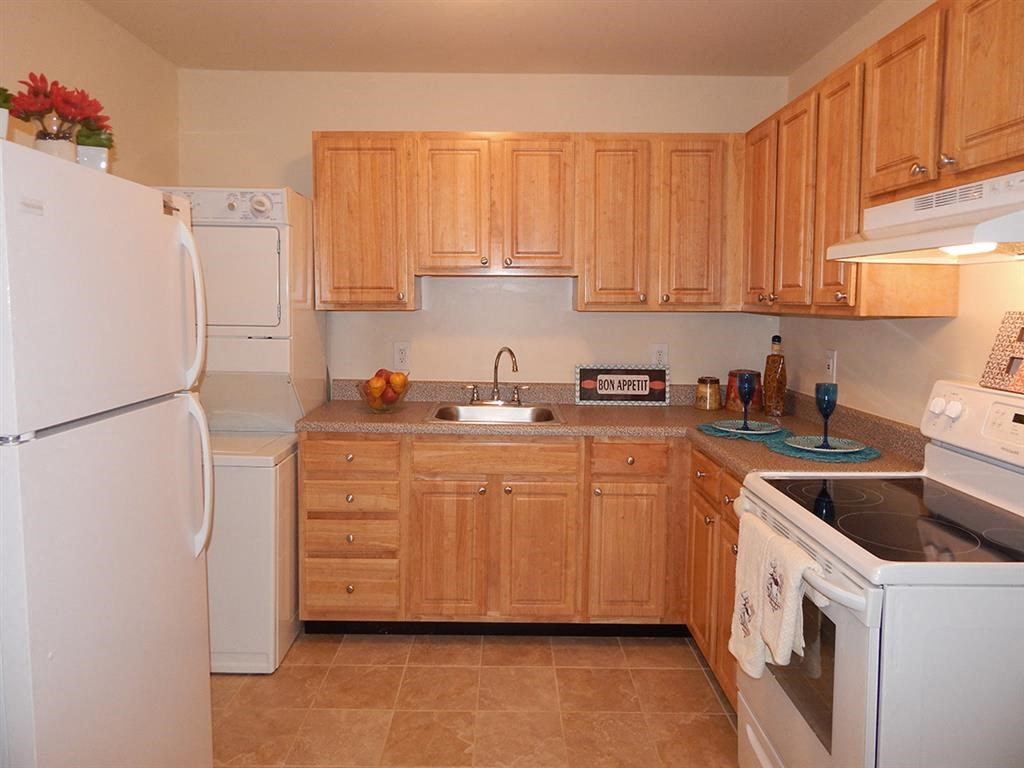 a kitchen with white appliances and wooden cabinets