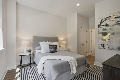 A bedroom with a large bed and a painting on the wall.