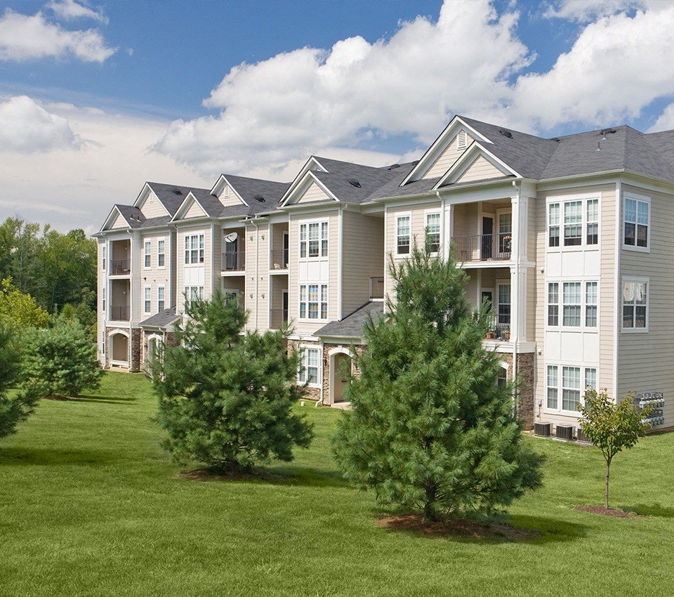 a large apartment complex with trees in front of it  at Harper's Crossing, Langhorne, PA