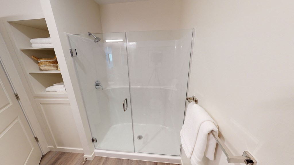 a shower with a glass door in a bathroom