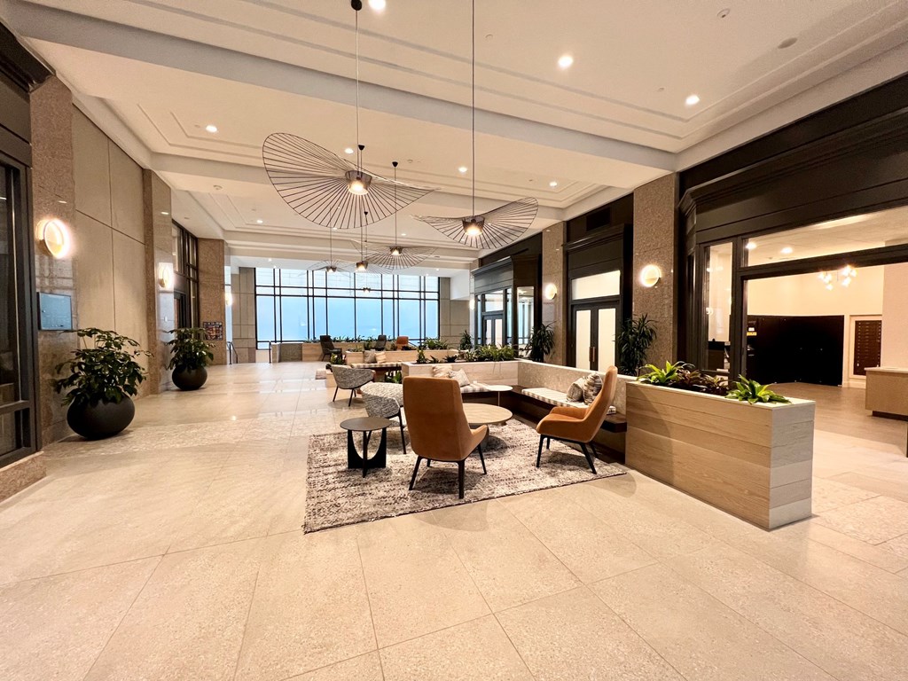 a large lobby with a table and chairs and large windows
