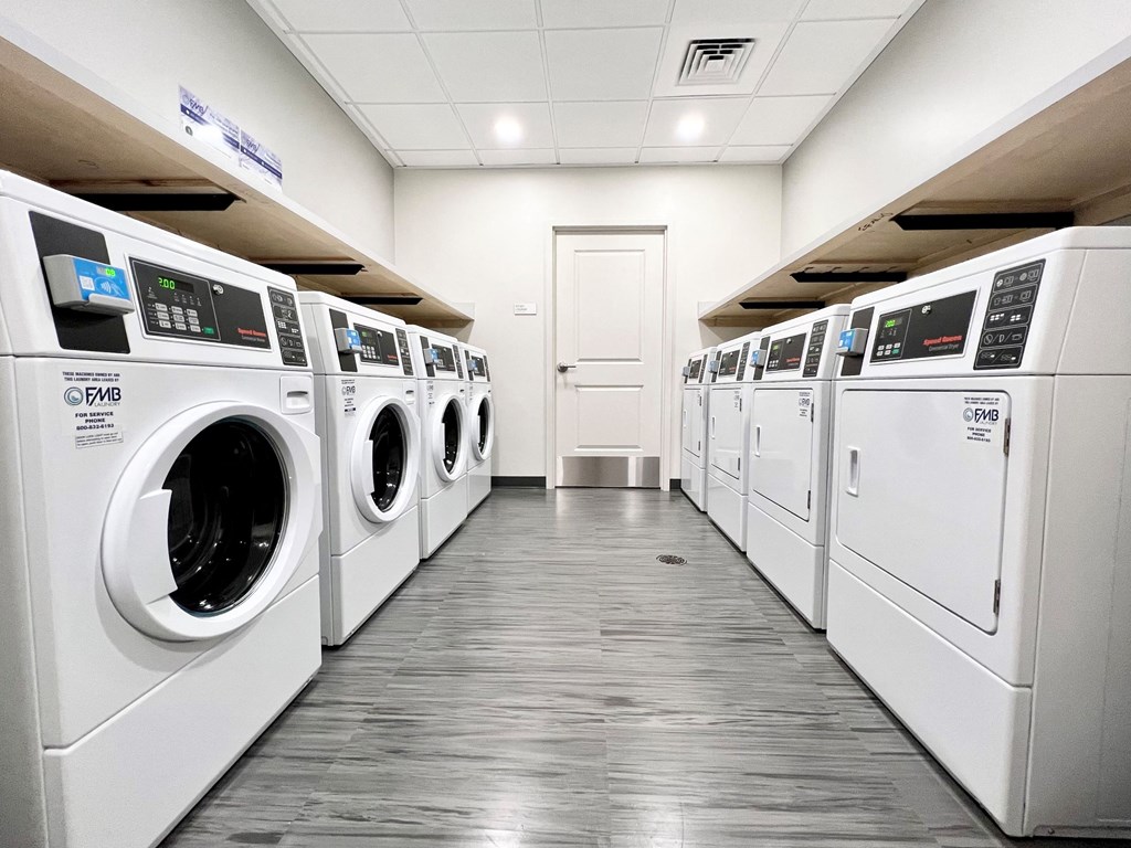 a row of washers and dryers in a laundry room