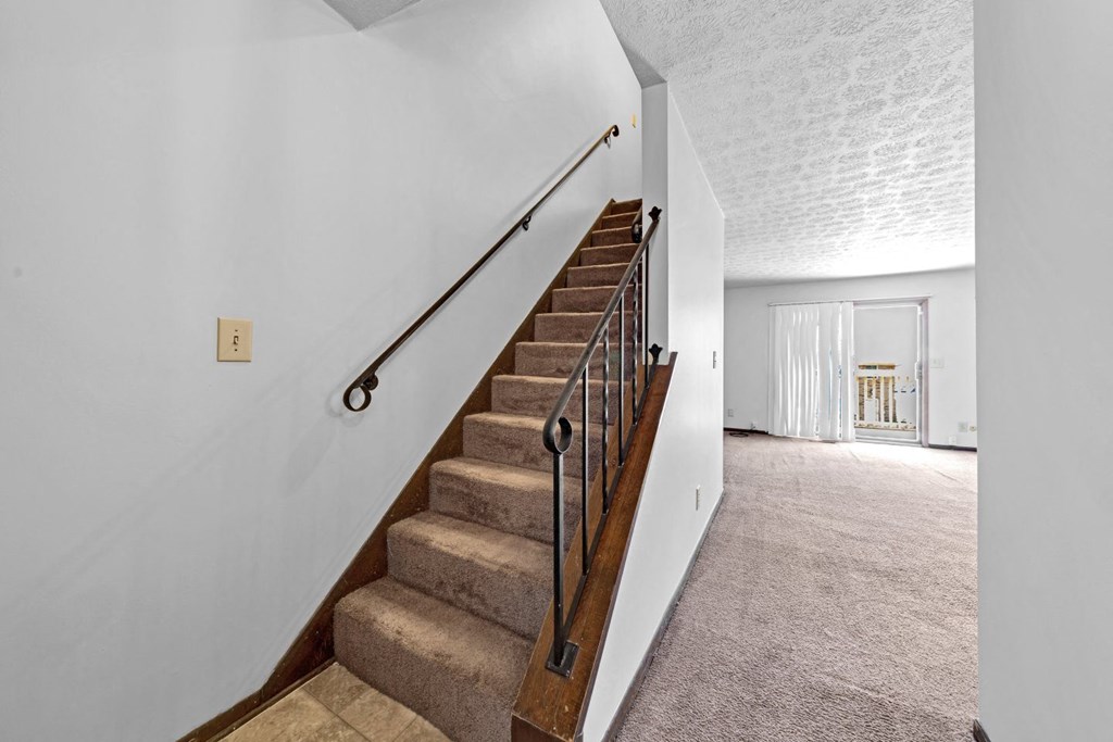 a staircase in a home with carpeted stairs and railings
