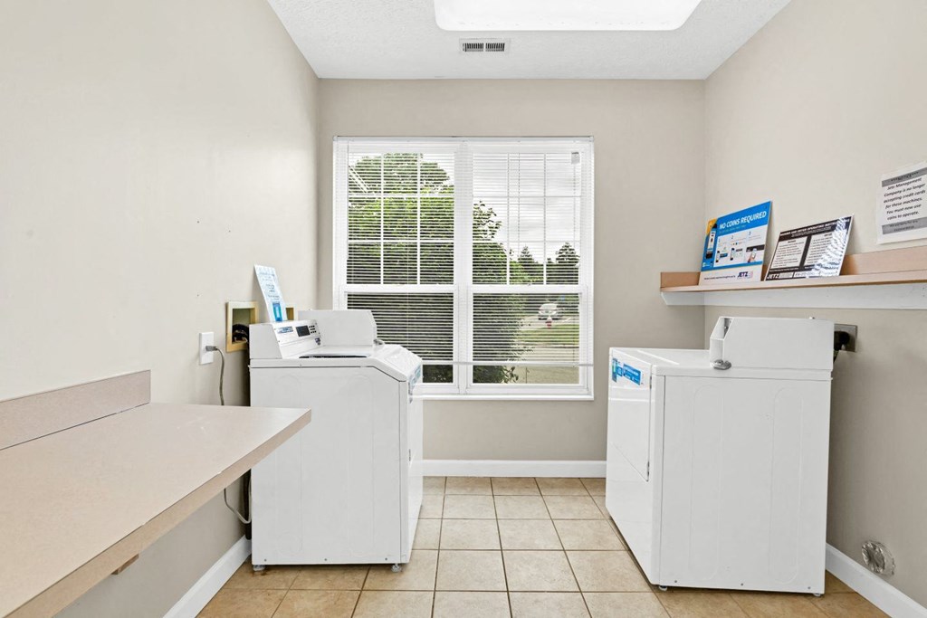 a laundry room with two washing machines and a window