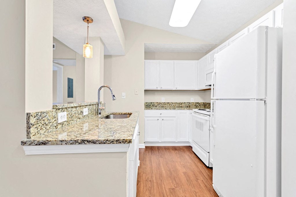 a kitchen with white appliances and granite counter tops