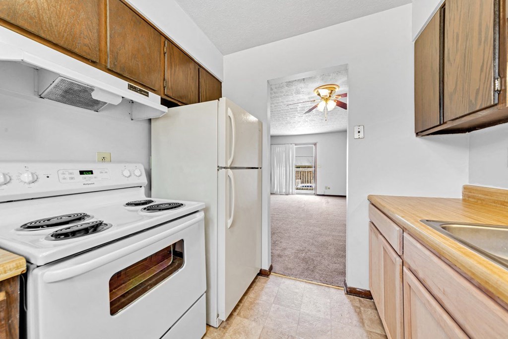 a kitchen with white appliances and a refrigerator