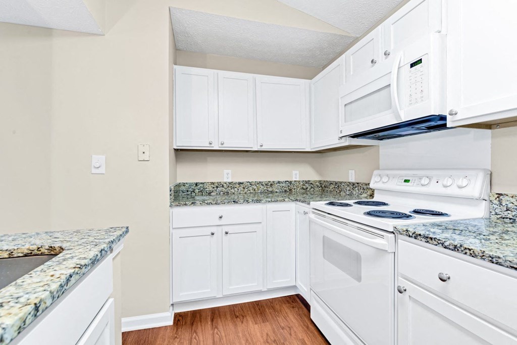a kitchen with white appliances and granite counter tops