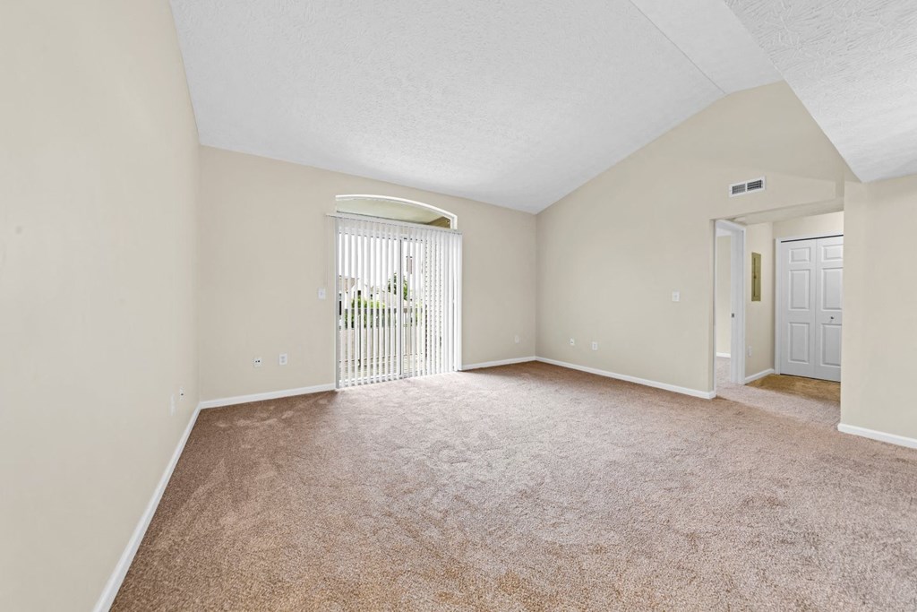 an empty living room with a door to a patio