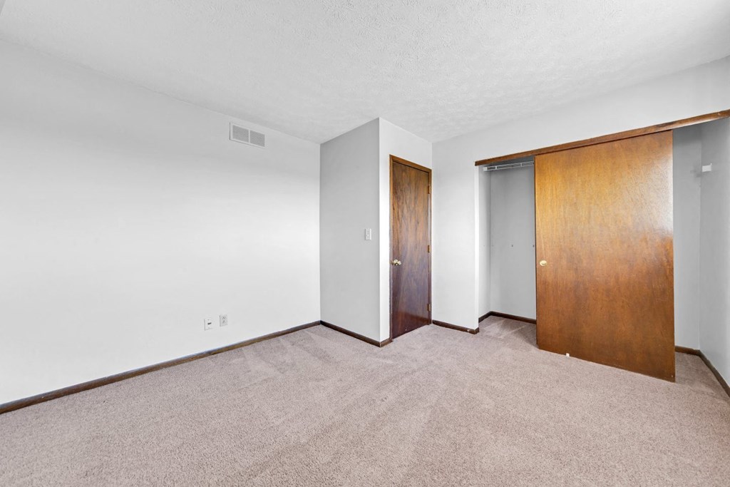 a bedroom with a closet and a door to a bathroom