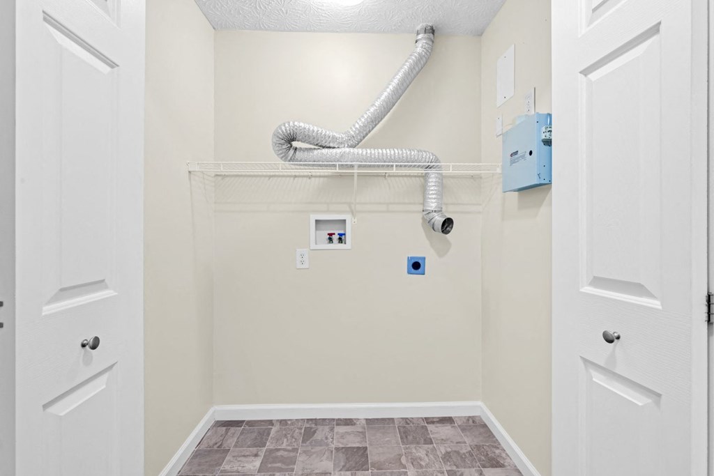 the closet in a bathroom with a pipe on the wall