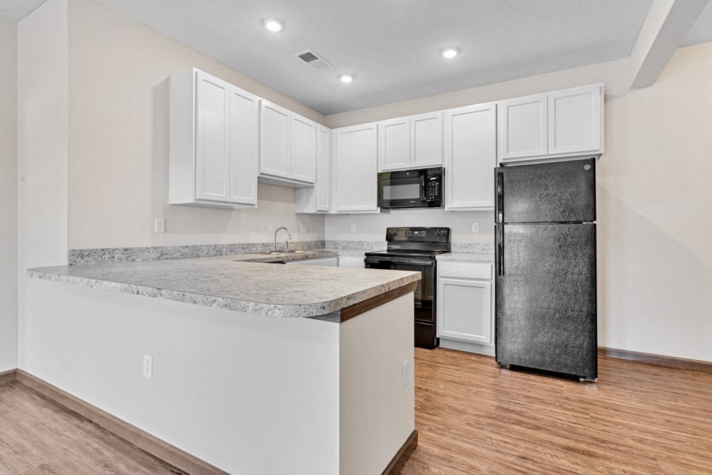 a kitchen with white cabinets and a stainless steel refrigerator