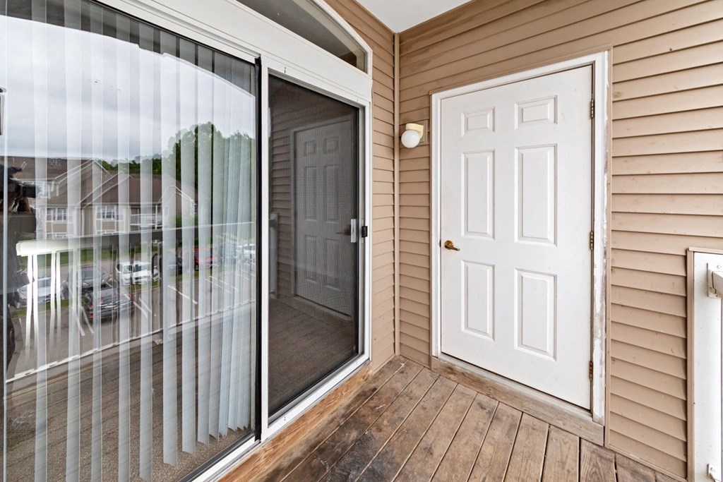 the entrance to a home with a white door and a patio door