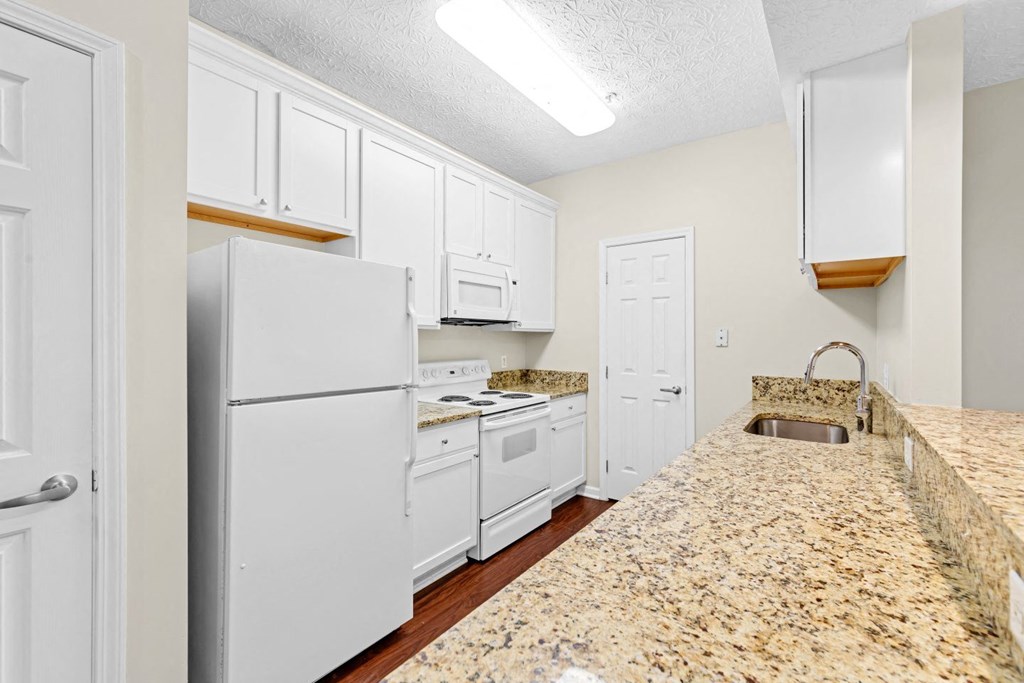 a kitchen with white appliances and granite counter tops