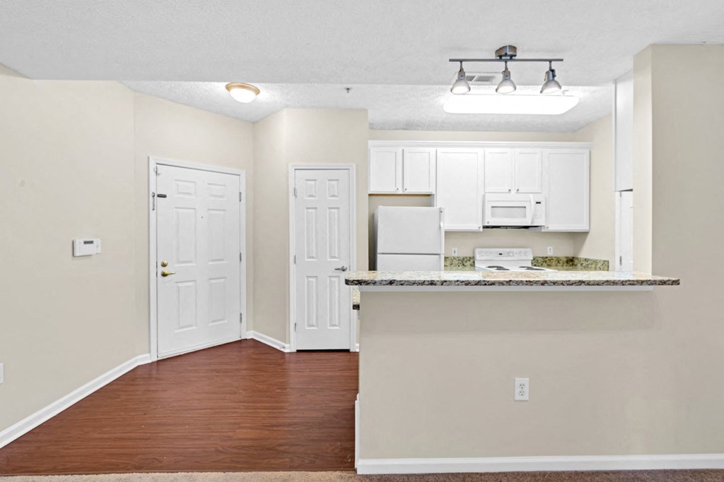 an empty living room and kitchen with a counter top