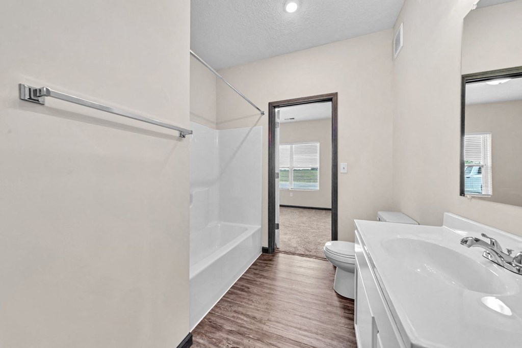 a bathroom with a shower and a sink and a toilet