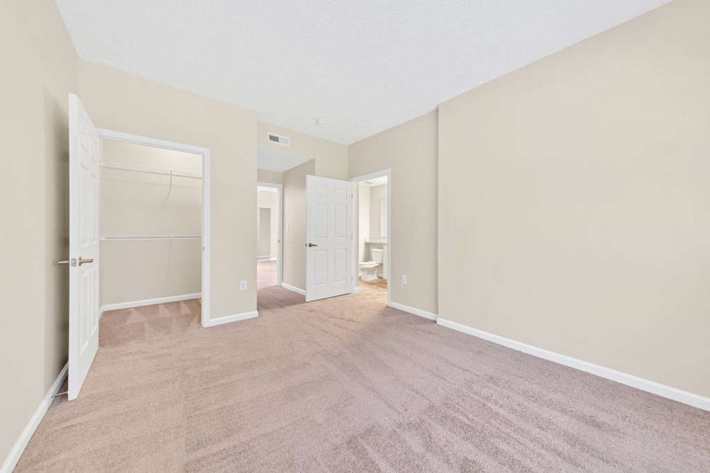 an empty living room with a closet and a door to a bathroom