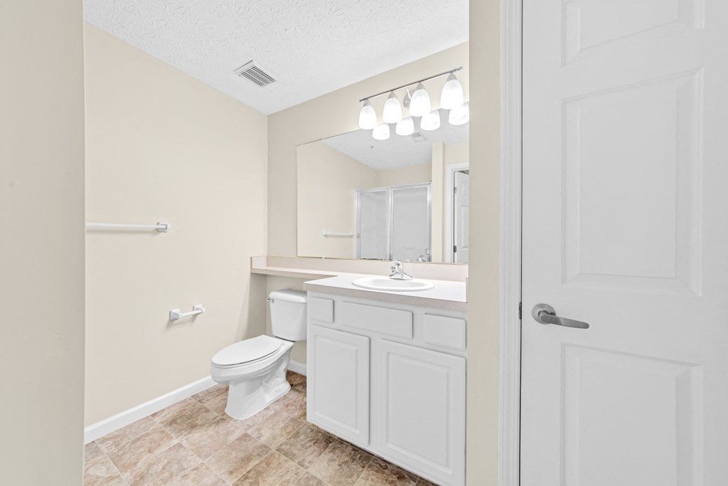 a white bathroom with a toilet and a sink