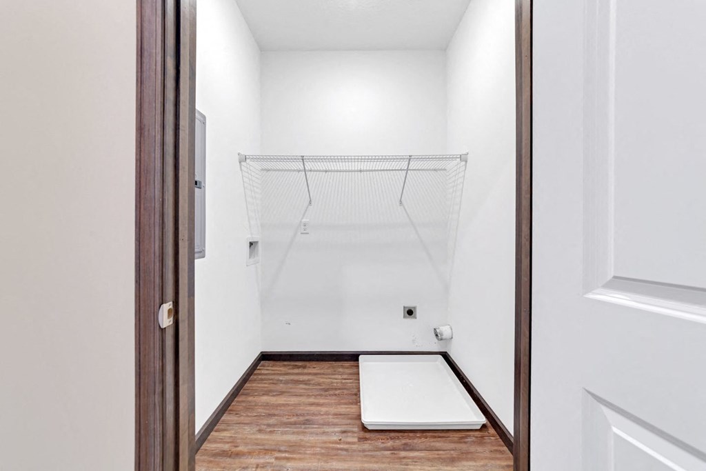 a white bathroom with a white shower and a wood floor