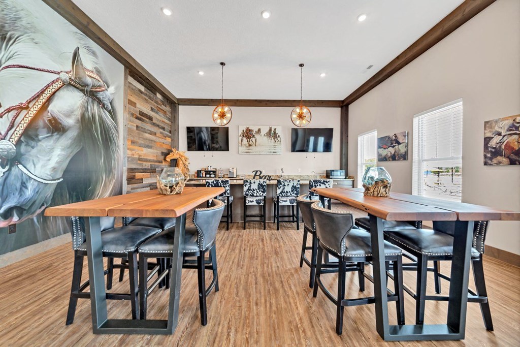 a dining area with tables and chairs and a large painting of a horse