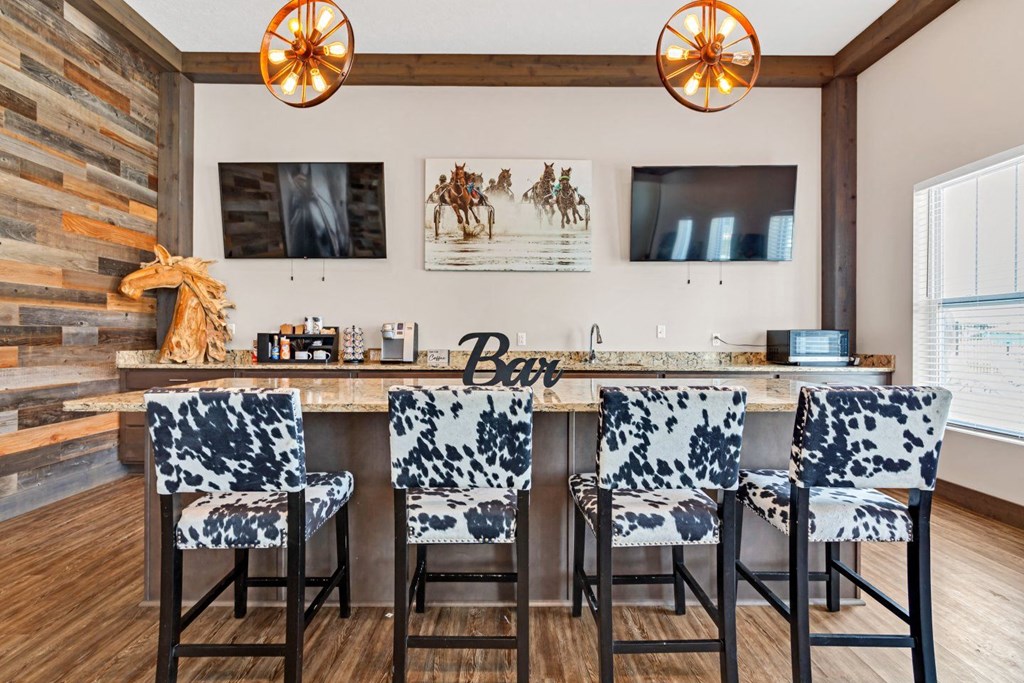 a bar with four bar stools in a living room with a television