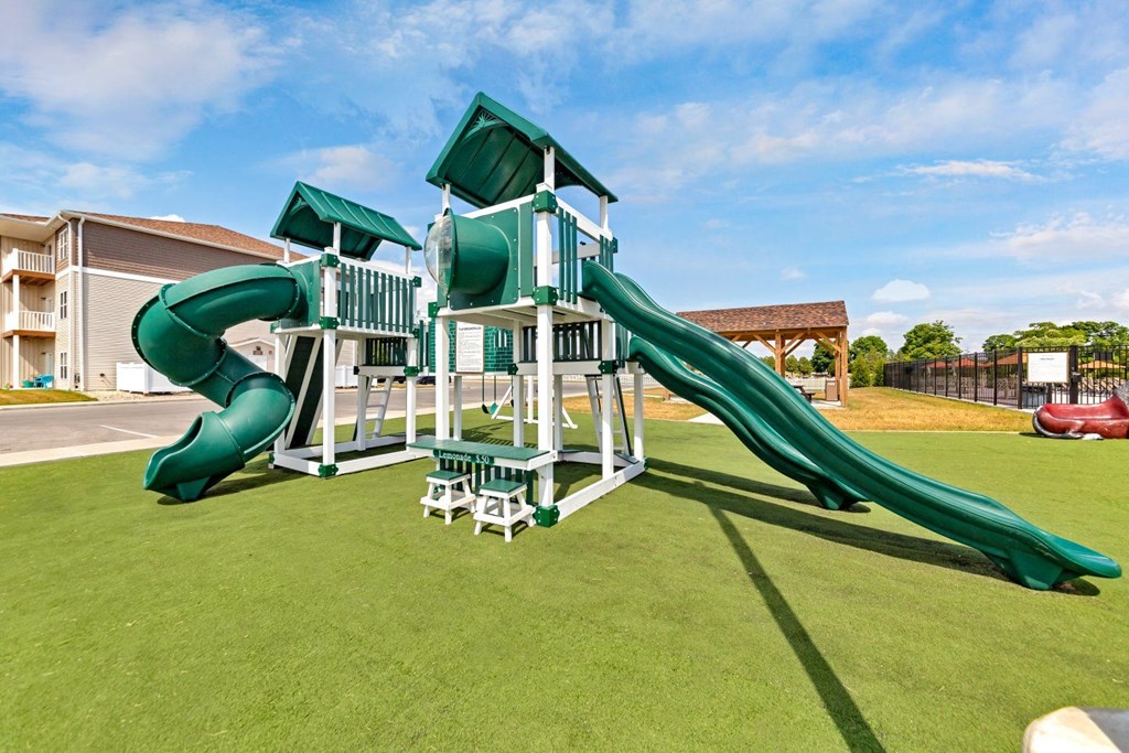 a playground with a large slide in front of a building