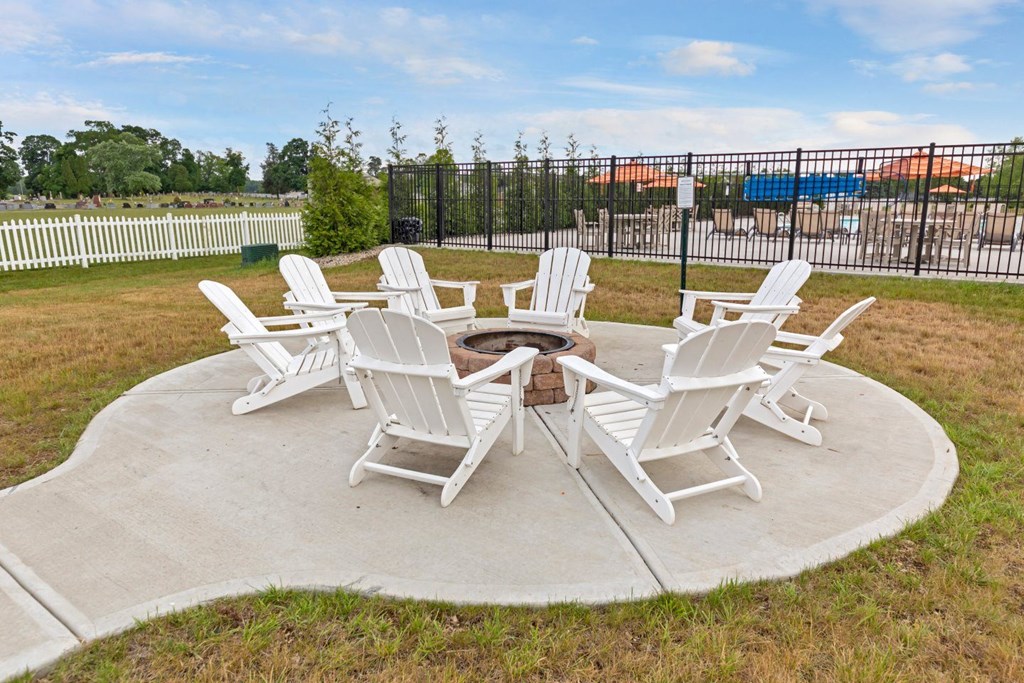 a fire pit with chairs around it on a concrete patio