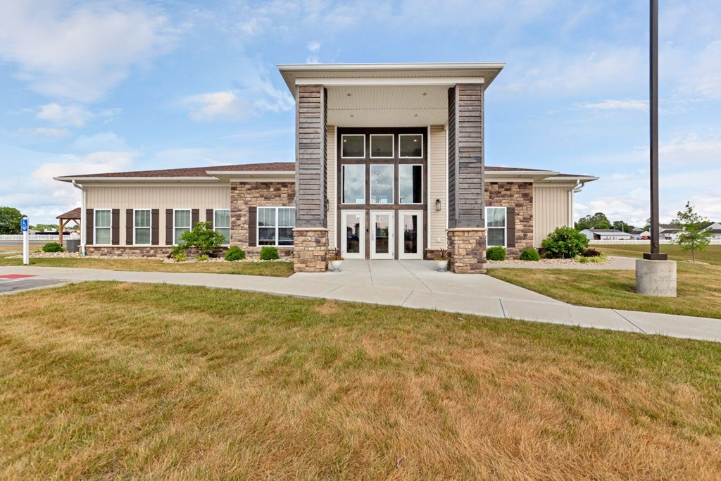 the front of a building with glass doors and a sidewalk