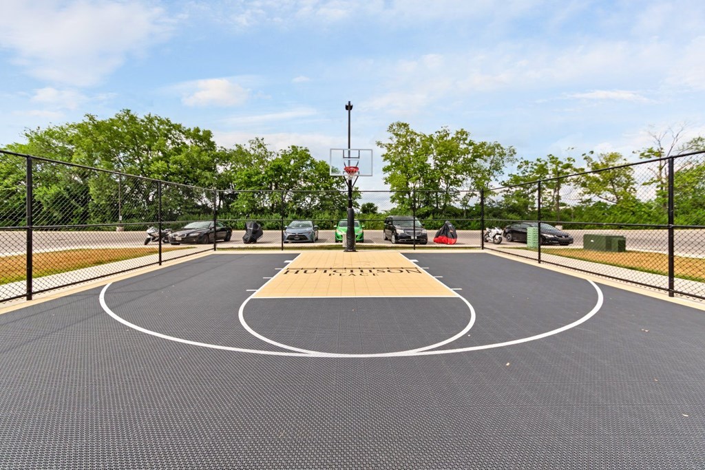 a basketball court at a park with trees