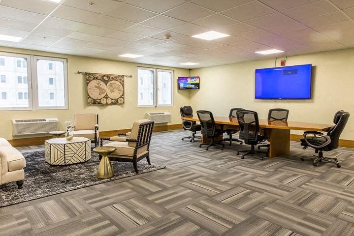 a conference room with a tv and a table and chairs