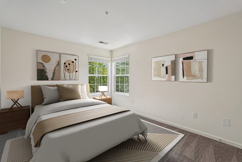 A bedroom with a large bed and two paintings on the wall.