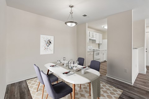 A dining room with a white table and chairs.