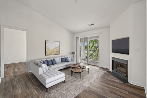 A living room with a white couch and a fireplace.