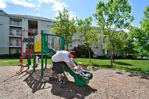 A man and a child playing on a playground.