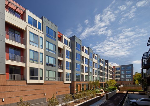 A row of modern apartment buildings with balconies and windows.